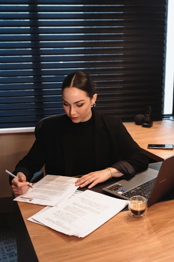 Thayna analisando documentos em sua mesa de trabalho
